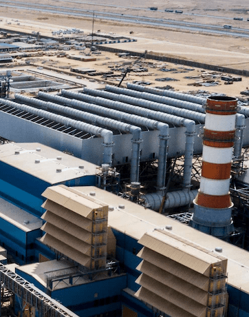 Industrial facility with large exhaust stacks.